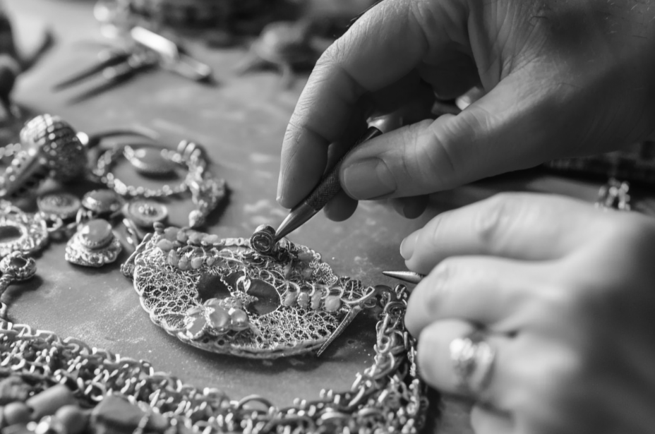 A pair of hands delicately crafting exquisite kiwified emerald jewelry
